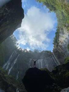 Tumpak Sewu Waterfall in East Java, Indonesia, surrounded by lush green cliffs and flowing water streams—one of the best waterfalls in Indonesia.