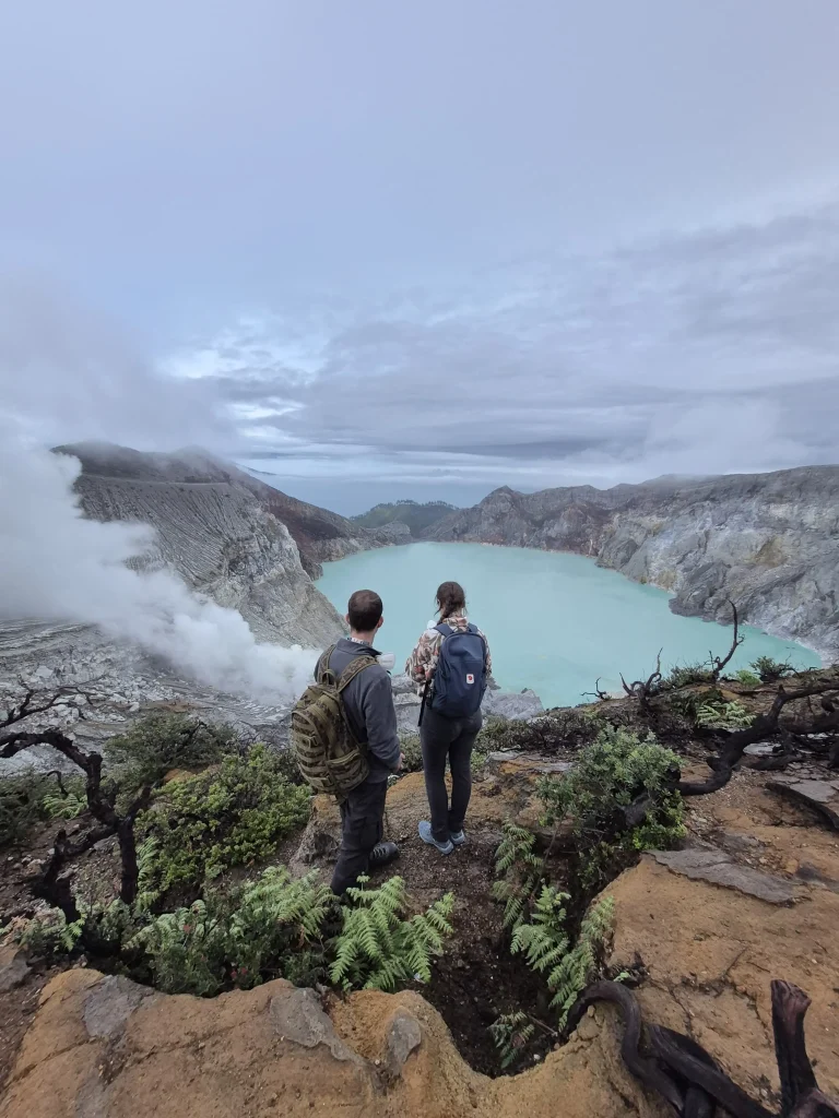 View of Ijen Crater with turquoise sulfur lake and volcanic smoke in Banyuwangi, East Java