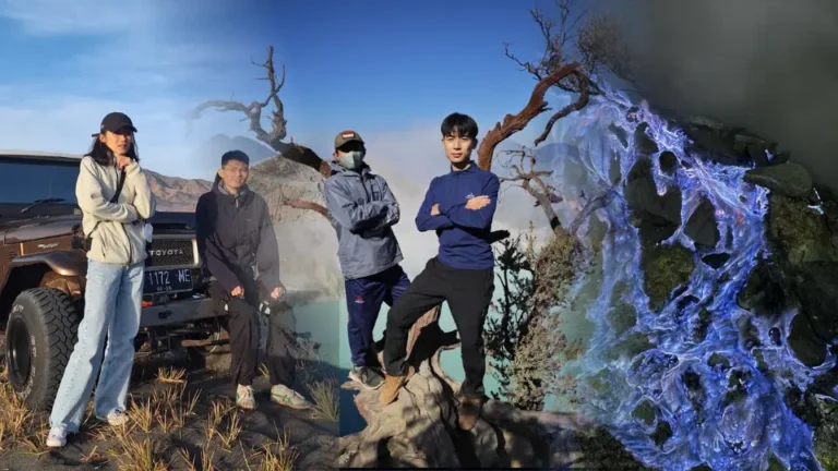 Sekelompok turis berfoto di dekat mobil jeep dan pohon mati ikonik Kawah Ijen dengan latar belakang asap belerang serta fenomena api biru (blue fire) yang menyala di malam hari.
